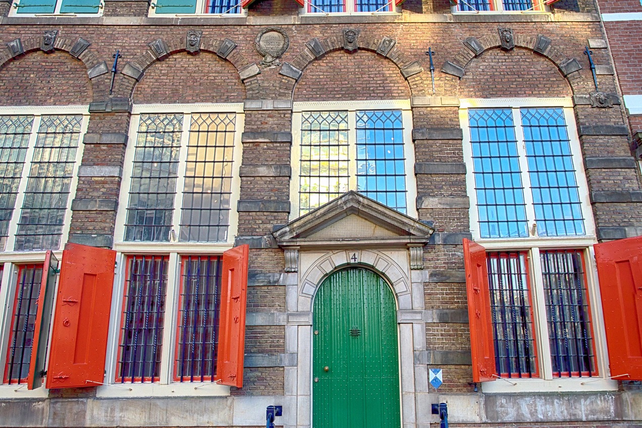 Historic Amsterdam brick facade with red shutters