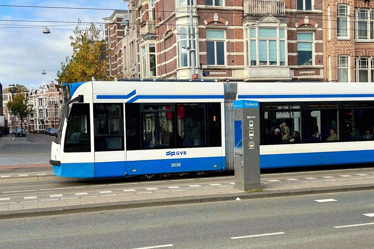 Blue-and-white GVB tram at a stop in Amsterdam