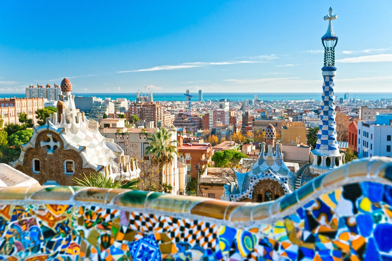 Colorful mosaic railing in Park Güell with a view over Barcelona