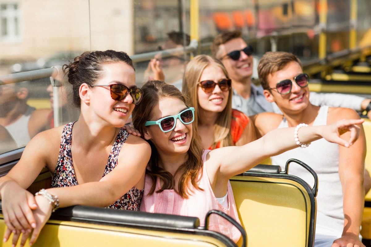 Young tourists on the upper deck of a hop-on-hop-off sightseeing bus