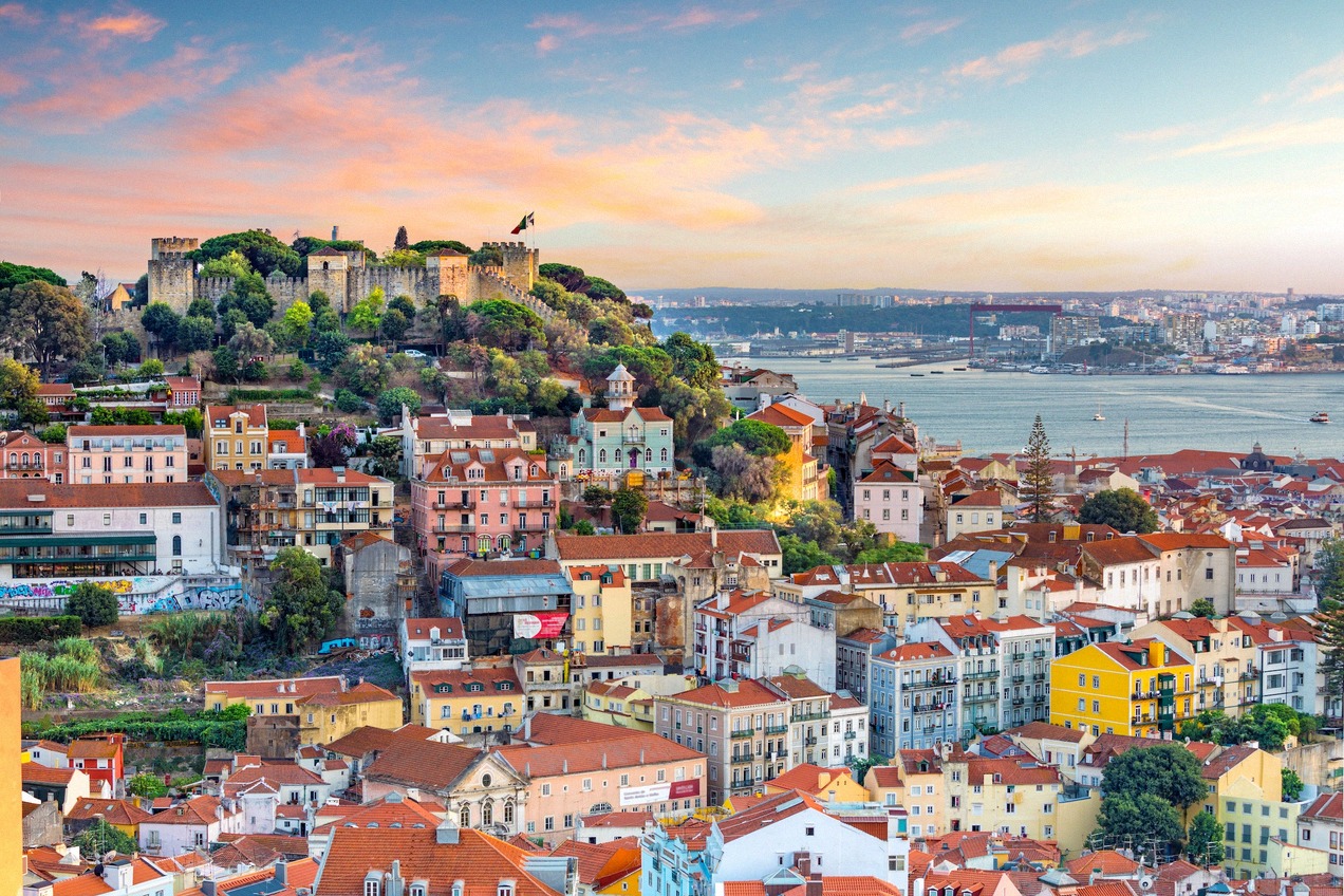Evening city panorama of Lisbon with the Castelo de São Jorge above Alfama and the Tagus