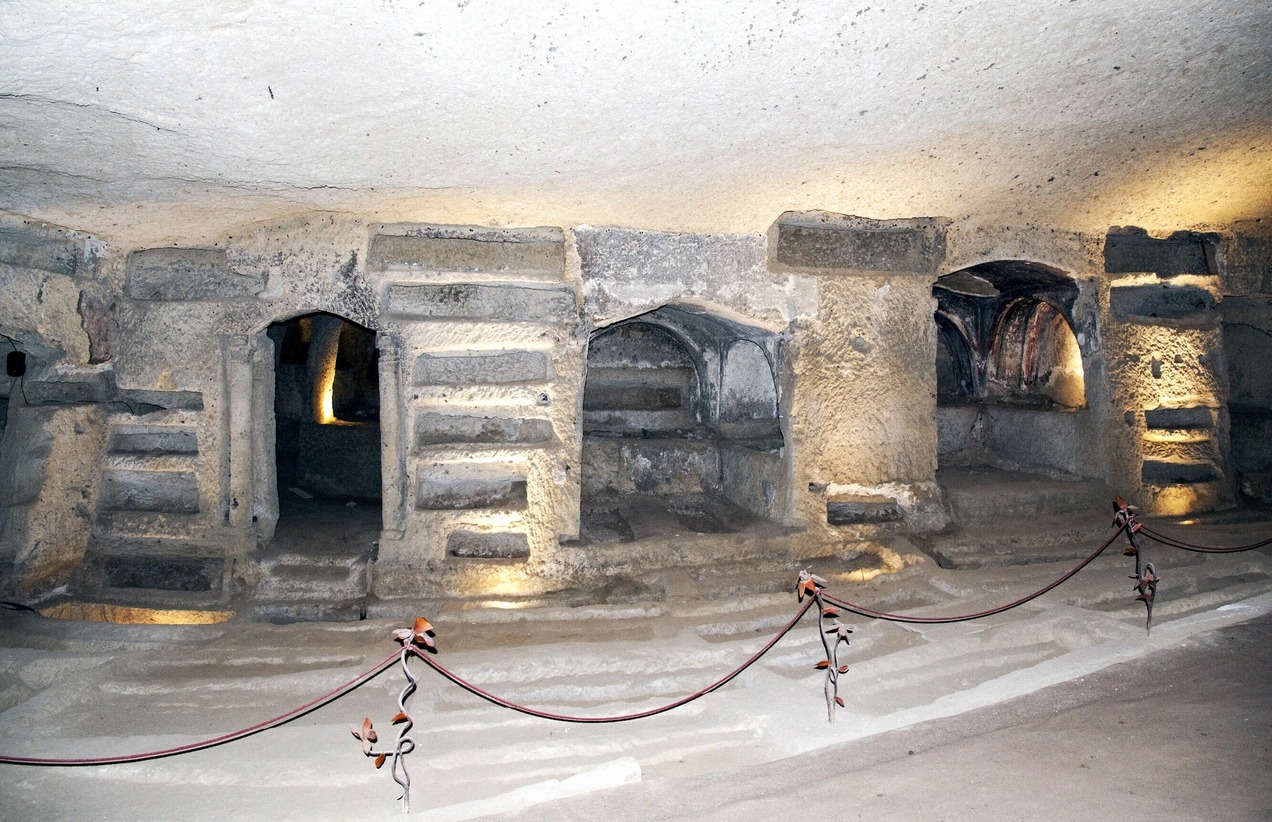 Niches and arches carved into the tuff stone of the early Christian Catacombs of San Gennaro in Naples