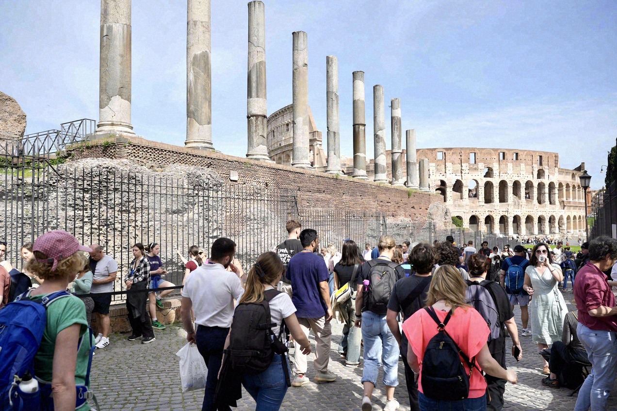 View over the Roman Forum with ancient rows of columns, the Colosseum in the background