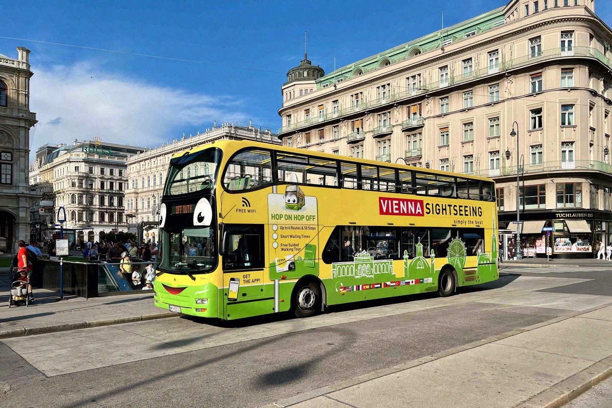 Yellow-and-green Vienna Sightseeing double-decker bus on the Opernring in front of Gründerzeit facades in central Vienna